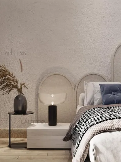 A detail of the bedside in this earthy, playful kid's room. The arched headboard and simple nightstand are set against a textured wall, creating a grounded and imaginative space.