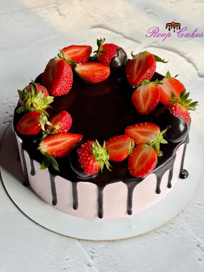 Sweet layers of chocolate and strawberry bliss. This cake features a rich chocolate drip over pink frosting, topped with fresh strawberries.