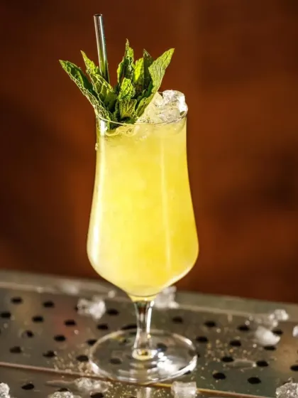 A bright yellow, citrusy cocktail served over a bed of crushed ice in a stylish glass. It's a perfect balance of sweet and sour.
