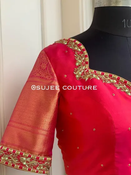 The front view of the pink blouse with silk sleeves. The sweetheart neckline is delicately outlined with gold embroidery, making it a versatile piece for many silk sarees.