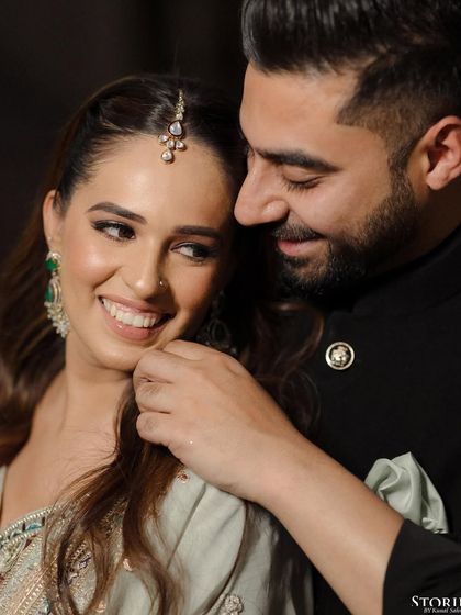 A tender moment between Anisha and Abhishek, his gentle touch and her bright smile telling a story of affection.