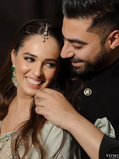 A tender moment between Anisha and Abhishek, his gentle touch and her bright smile telling a story of affection.