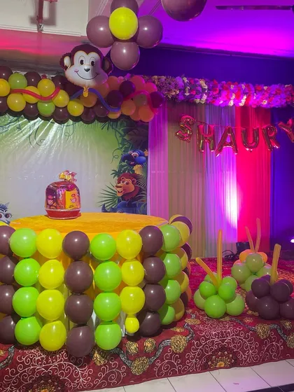 I love bringing kids' favorite themes to life. This is a fun Jungle theme setup with a cake table wrapped in green and brown balloons, an arch with a monkey foil balloon, and a backdrop featuring friendly jungle animals.
