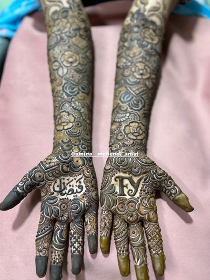 A closer look at the palms, showing the beautiful calligraphy of the name and the bold initials.