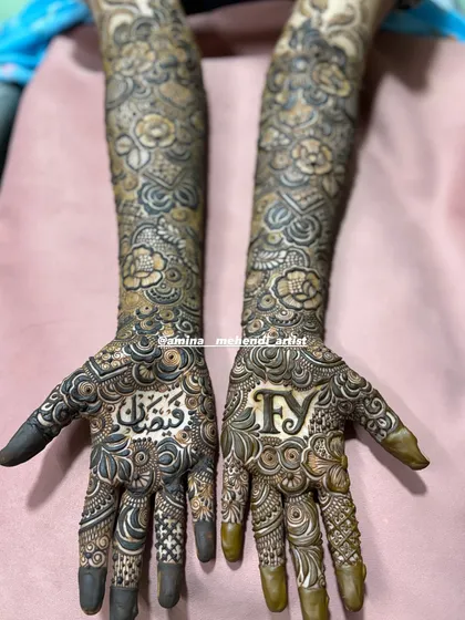 A closer look at the palms, showing the beautiful calligraphy of the name and the bold initials.