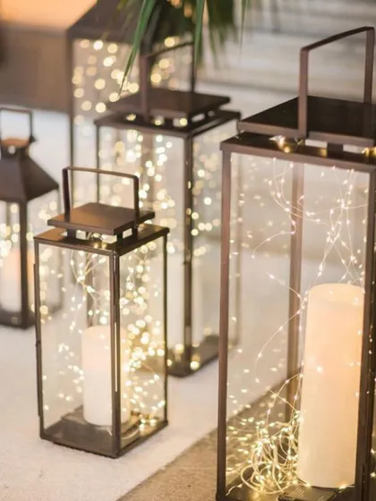 I love using lanterns filled with fairy lights to illuminate walkways and corners. These elegant pieces add a sophisticated and warm glow to any event space, whether indoors or out.