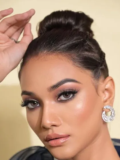 A close-up of a high bun with braided details at the side. This adds a touch of texture and interest to a classic updo, perfect for a glamorous evening look.