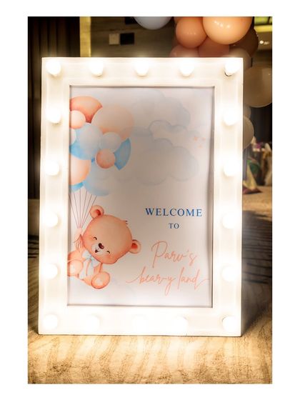 A close-up of the custom welcome sign for the teddy bear party. The marquee-style frame with built-in lights adds a special glow and highlights the cute teddy bear illustration.