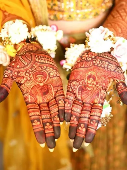 A stunning photo showcasing the bride's portrait mehendi and the rich, dark stain. The floral jewelry adds a beautiful touch to the overall look.