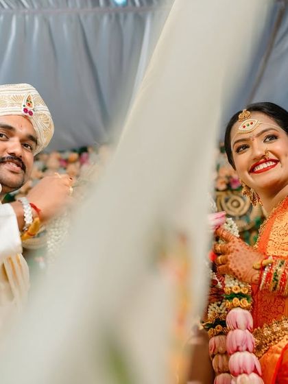 A candid moment between the bride and groom during the garland exchange ceremony. The bride's radiant smile says it all.