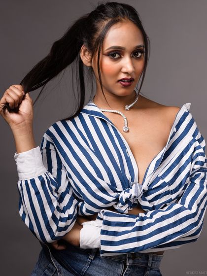 A direct-to-camera portrait in the striped shirt, with a strong and engaging gaze.