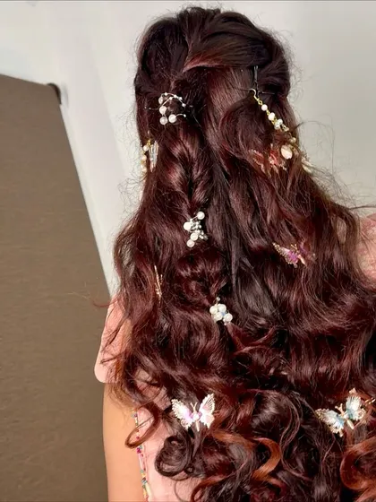An up-close shot of the hair accessories. The combination of pearls and butterflies scattered through the curls and braid creates a truly unique and magical effect.