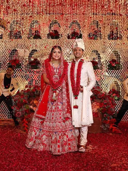 Nothing says classic Indian wedding like the color red. This reception stage is drenched in red, from the floral carpet to the intricate backdrop, creating a powerful, romantic, and cinematic setting for the couple's grand celebration.