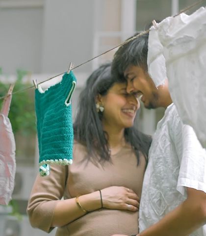 A sweet, intimate moment captured during our baby clothesline themed shoot. The tiny outfits in the foreground are a lovely symbol of the future they are building together.