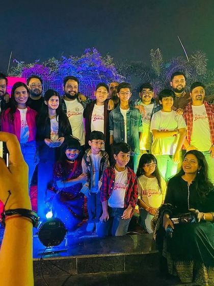 A big group photo on stage with the entire performance team. Capturing the memory of a successful show.