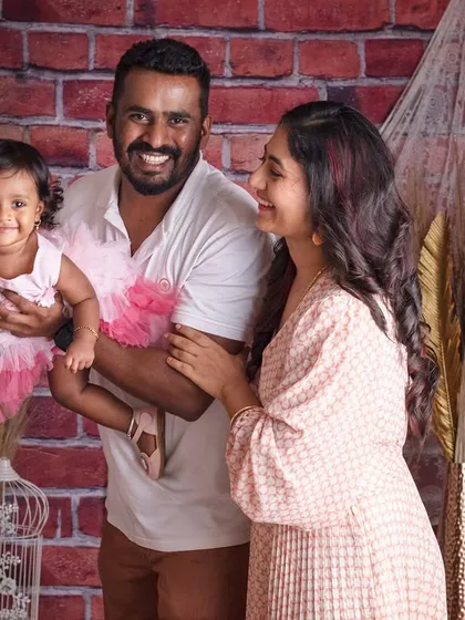 A simple, candid family portrait that is full of warmth and connection. Against a rustic brick backdrop, this moment between parents and their little one shows that sometimes, the most powerful photos are the most natural ones.