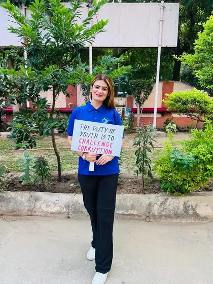 Holding a sign that reads "The duty of youth is to challenge corruption." I stand by this principle and believe in upholding integrity in all aspects of life.