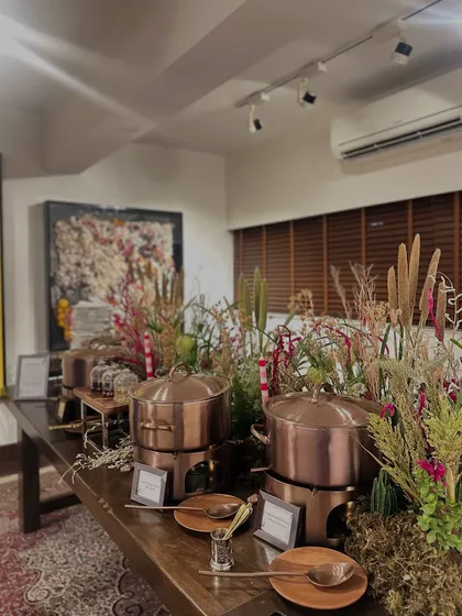 A rustic yet elegant buffet setup with copper serving pots and dried floral arrangements, creating a warm and inviting atmosphere.