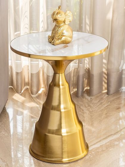 The Golden Glow side table is elegant, useful, and striking. Its tapered, tiered golden base is made from stainless steel and is topped with a clean white artificial marble surface, perfect for holding a lamp or your favorite decor.