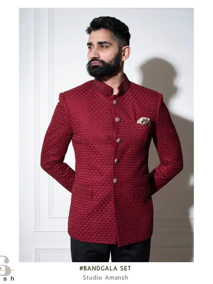 The crimson bandhgala, shown here with a pocket square, demonstrates its versatility. The rich, textured material catches the light beautifully, making it an exceptional choice for wedding receptions and formal celebrations.