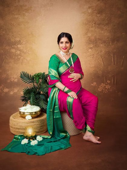 A full-length portrait showcasing the unique drape of the Maharashtrian 'nauvari' saree. The rich colors and traditional styling make for a stunning cultural photograph.