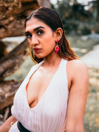 A stunning close-up portrait in a beautiful white gown. The natural, rustic background provides a perfect contrast to her elegant look.