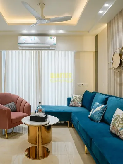 This living area in Gurugram is a sanctuary of modern luxury. I designed this space to be both sophisticated and comfortable, using a rich color palette with a vibrant teal sofa, elegant fluted wall panels, and statement gold accents to create a curated experience for daily living.