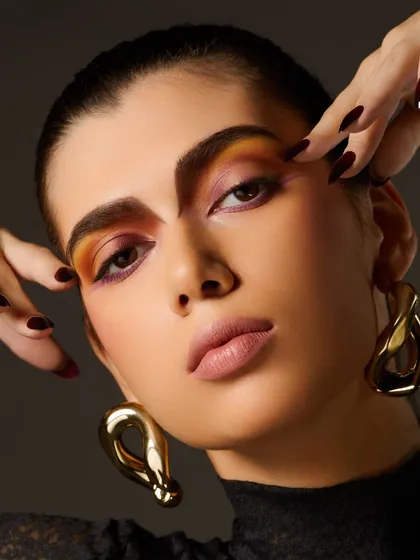 A powerful editorial look with bold, blended eyeshadow and sculpted brows. This image from a Delhi student's portfolio shows a unique and artistic approach to makeup.