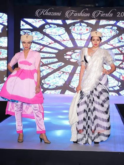 Two distinct looks from the same student collection at the Khazani Fashion Fiesta 2018. The designs showcase a creative use of fabric and silhouette, from a layered pink tunic to a draped saree-inspired gown.