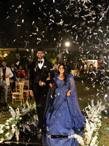Making a grand entrance as husband and wife. We planned this spectacular reception for Raksha and Ram, complete with a confetti shower and a reflective aisle, ensuring their first moments as a married couple were as dazzling as their love story.
