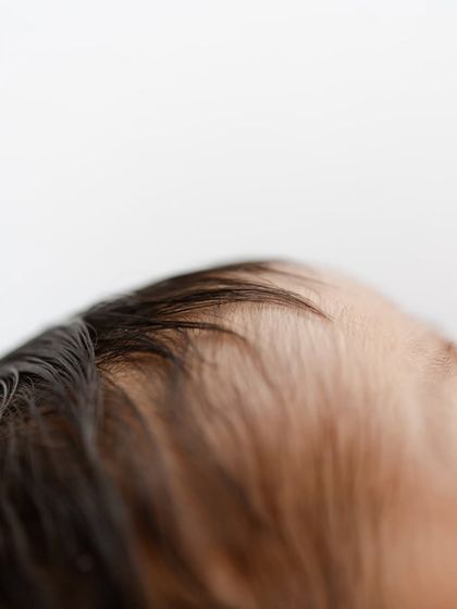 The soft, fine hair on a newborn's head. These are the fleeting details that change so quickly.