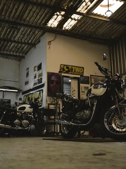 The Greasehouse is where the magic happens. Here are a couple of classic Triumph Bonnevilles in for service, soaking in the workshop atmosphere.