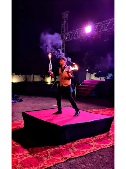 A full shot of our flair bartender on stage, manipulating flaming bottles. This act combines smoke and fire for a truly memorable entertainment piece during an evening event.