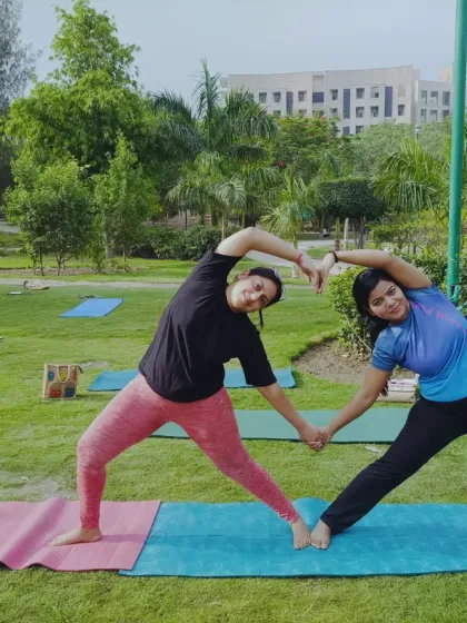 Two students form a heart shape with their bodies during our outdoor yoga class. Partner poses like this add an element of fun and connection to the practice.