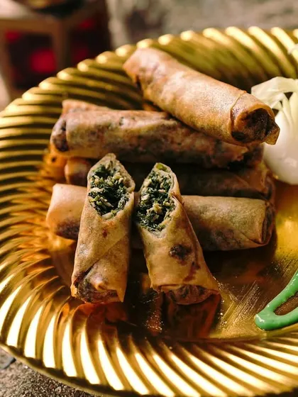 These Spinach Chicken Cigars are rolled tight and spiced right. The crispy shell gives way to a savory filling of chicken and spinach, served with a vibrant green chutney.