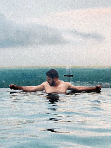 A moment of relaxation in an infinity pool overlooking the city. This lifestyle shot combines urban scenery with a sense of calm and luxury.