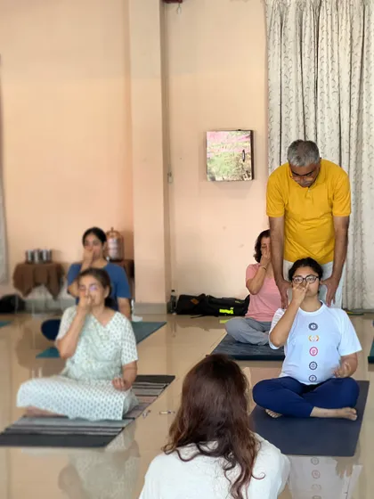 A teacher observes her students during a pranayama class, ensuring everyone is practicing correctly and comfortably.