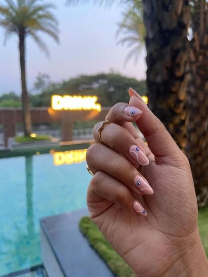 My client showing off her evil eye nails by the pool. The design looks so chic and is perfect for a vacation.