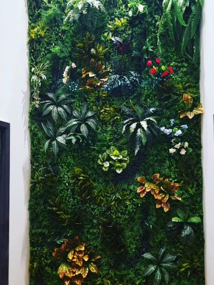 A close-up view of a mixed-foliage vertical garden. I combine different leaf shapes, colors, and sizes, including red and yellow accents, to create a vibrant and realistic plant wall.