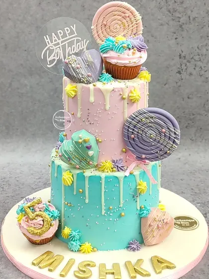 Welcome to Candyland! This vibrant, three-tiered non-fondant cake is a dream for anyone with a sweet tooth. We used a colorful drip effect and adorned it with handmade lollipops, cupcakes, and geometric hearts for a fun, whimsical look perfect for a big birthday bash.