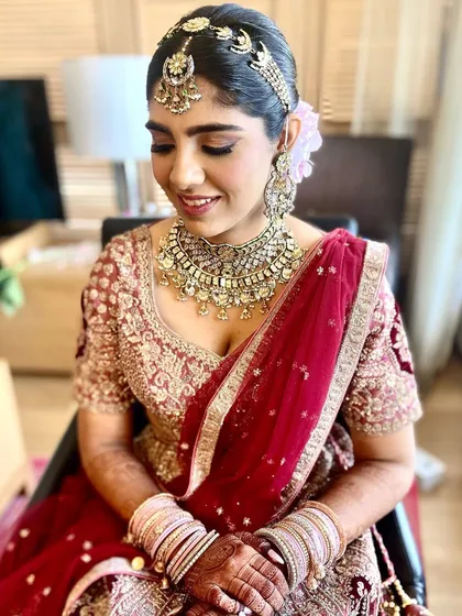 The bride's happy face says it all. This updo is designed to hold a heavy dupatta and jewelry while remaining comfortable.