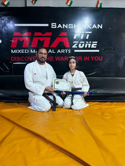 A young female student earns her blue belt, demonstrating her growing skill and dedication in our karate program.