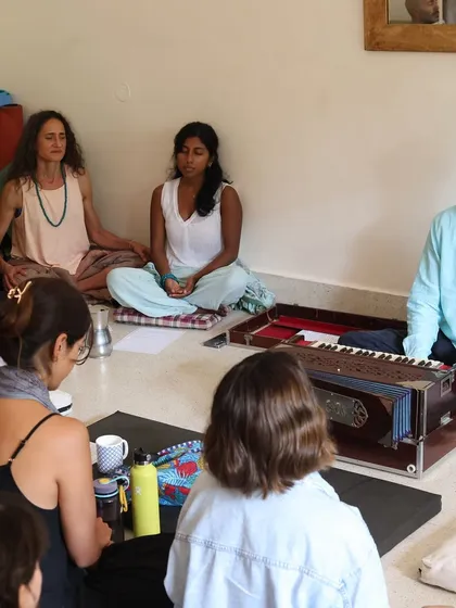 A teacher leads our kirtan session with a harmonium, guiding us through mantras. These gatherings are a beautiful way to integrate philosophy, storytelling, and chanting into a holistic yoga experience.