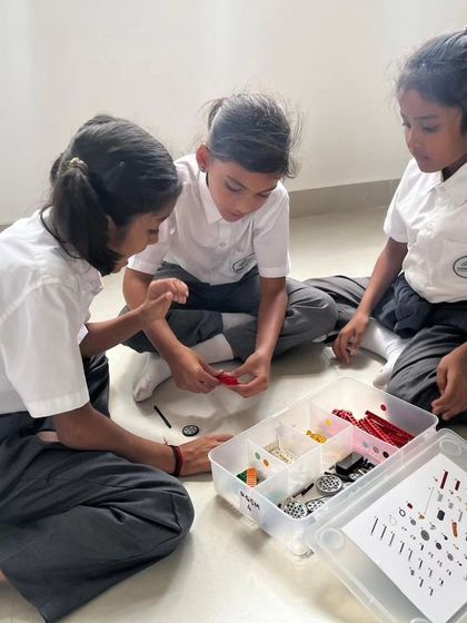 Students from Sadhu Vaswani International School collaborate on the floor, engrossed in a LEGO Education challenge. We bring our programs directly to schools to make STEM accessible.