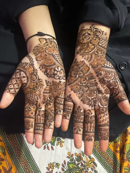 Here's another Eid henna design, with a mix of geometric and floral elements. The diagonal division of the palm creates a unique and modern feel.