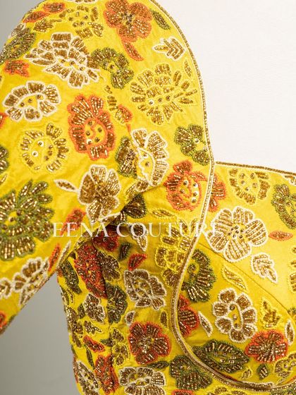 Another take on the yellow raw silk blouse, this piece features a classic Katori cut. The front is kept simple to highlight the fit, while the back and sleeves are adorned with a vibrant floral pattern in multi-colored beadwork.