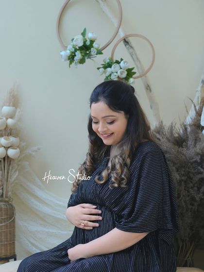 A quiet moment of connection. This solo portrait in a cozy, boho-inspired studio setting captures the gentle love a mother feels for her unborn child.