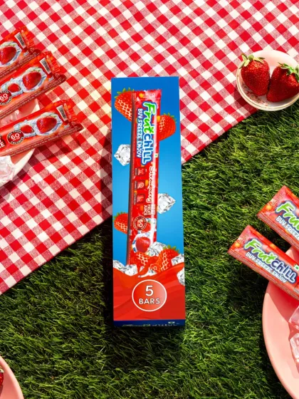To create a fun picnic vibe, we styled these strawberry fruit pops on a bed of artificial grass with a classic red and white checkered cloth. Fresh strawberries and ice cubes complete the scene, making it feel like a perfect summer day out.