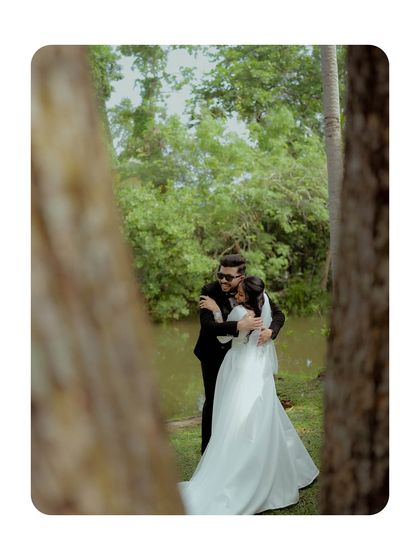 A stolen moment, a private embrace captured from a distance, framed by trees. This adds a candid, story-like quality to their wedding album.