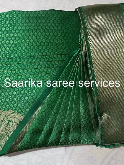 A dark green saree with silver motifs, folded to keep it pristine.